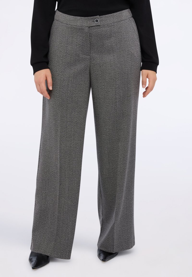 Šedé vzorované kalhoty s širokým střihem, s plochým pasem a zapínáním na knoflík, doplněné o špičaté černé boty.
