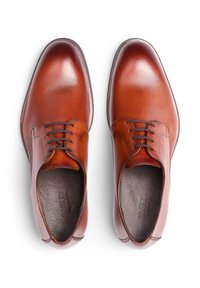 Un paio di scarpe eleganti da uomo in pelle marrone lucida, allacciate, viste dall'alto, con punte arrotondate lisce e fodera interna scura.