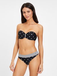Zwarte bikini met stippen, voorzien van een strapless top met een centrale ruffles en een gestreepte band om de taille. Glad materiaal en aansluitend ontwerp.