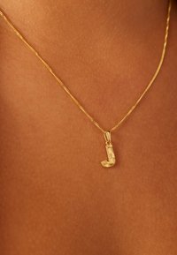 Goldanhänger-Halskette mit einem stilisierten "J"-Charm, kunstvoller Gravur und feiner Kette, die auf der Haut liegt.