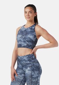 Blå mönstrad crop top och leggings-set tillverkat av texturerat tyg, med en bergliknande design, åtsittande passform och breda axelremmar.