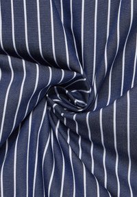 Marineblaue Stoff mit weißen vertikalen Streifen, der eine strukturierte Webart aufweist. Das Material ist glatt und in einem wirbelnden Muster angeordnet.