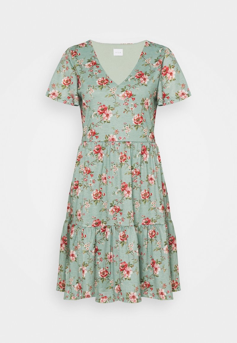 Robe verte à manches courtes avec imprimé floral rose et rouge, décolleté en V et jupe à volants.