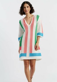Abito in crochet bianco con strisce verticali verdi, rosa e blu. Presenta un collo a V e maniche a tre quarti, con una vestibilità rilassata.