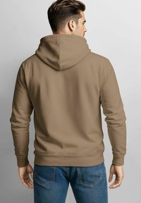 Brauner Hoodie mit einer großen, weichen Kapuze, gerippten Bündchen und Saum. Getragen mit blauen Jeans, die eine lässige Passform und glatte Textur zeigen.