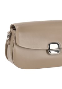 Bolso bandolera de cuero beige con forma curva, cierre de solapa y broche metálico. Textura lisa con un brillo sutil.