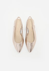 Paire de ballerines slingback métalliques roses à bout pointu, avec petites brides et semelles intérieures beiges sur fond blanc.