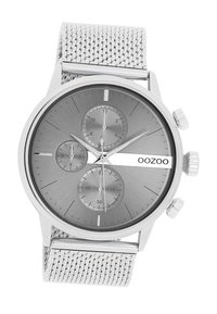 Montre avec bracelet en mailles argentées, affichant un cadran gris avec trois sous-cadrans, des index horaires argentés et un logo de marque bien en vue. Design épuré et moderne.