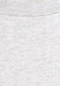 Tessuto di cotone grigio chiaro con una texture morbida e scollo a costine. Il materiale presenta un sottile motivo mélange in tutto il suo sviluppo.