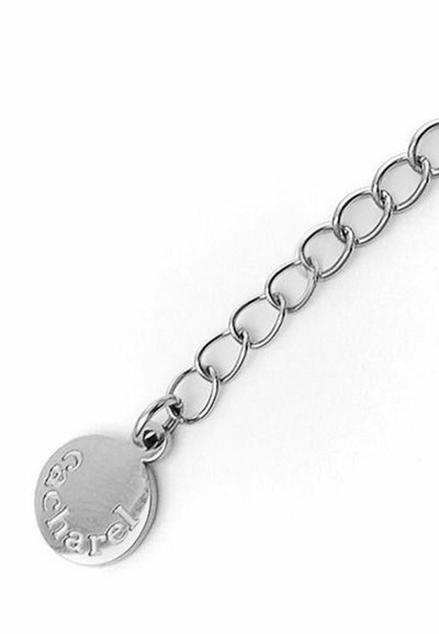 Pulsera de metal plateado con una gran cadena entrelazada, que presenta un charm redondo grabado con "Chacarel". Textura suave y acabado brillante.