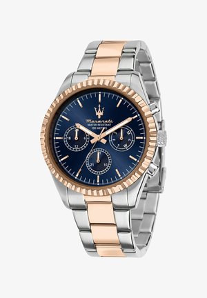 Sølv- og rosaguldur med en blå urskive, der har tre små urskiver, en struktureret bezel og et sammenkoblet armbåndsdesign. Vandtæt op til 100 meter.