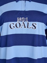 Svītrainā polo krekls ar maiņojošām tumši zilām un gaiši zilām joslām. Uz priekšpuses ir izšuvums "NO1 GOALS" baltā krāsā.