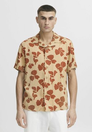 Short-sleeve button-up shirt in beige with large red floral patterns. Features a collar and a relaxed fit, suitable for casual wear.
