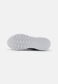 Semelle d'une sneaker, composée d'un matériau en caoutchouc blanc avec un motif en diamant texturé pour une meilleure adhérence et durabilité.