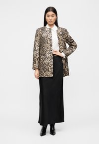 Μπλέιζερ με τύπωμα λεοπάρδαλης από απαλή ύφανση με άνετη εφαρμογή. Συνδυασμένο με λευκό πουκάμισο με γιακά και μαύρη μακριά φούστα, ολοκληρωμένο με μαύρα μποτάκια.