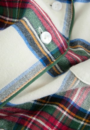 Bordo, žalia, raudona ir mėlyna plaid flanelinė marškinė cream spalvos su baltais mygtukais; turi minkštą tekstūrą ir kontrastingą žalią apdailą aplink apykaklę.