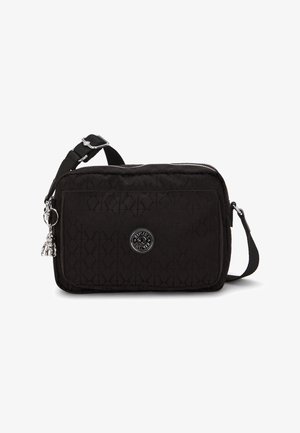 Black quilted fabric crossbody bag with a zip closure, silver hardware, a round emblem, and a detachable charm accent. Adjustable strap.