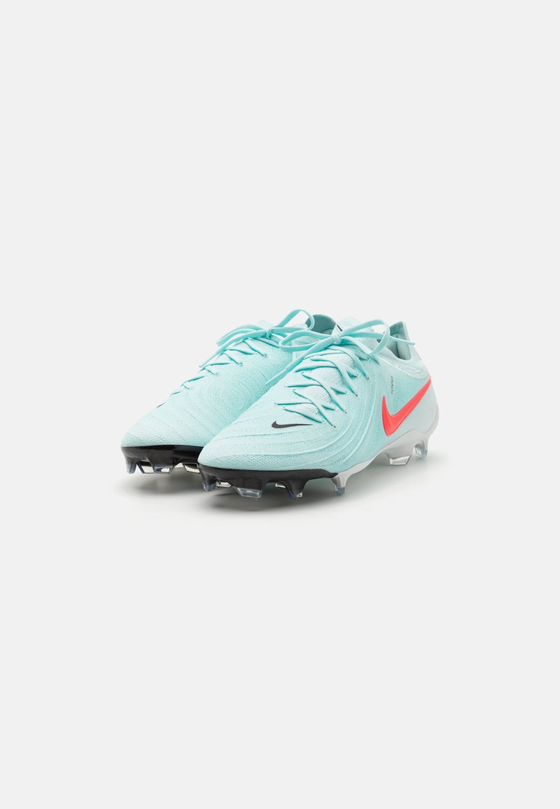 Botas de fútbol azul claro con diseño texturizado, suela negra y swoosh rojo de Nike. Cuentan con cordones y tacos moldeados para mayor tracción.