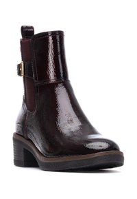 Botín de tobillo de imitación piel burdeos con un acabado brillante, paneles laterales elásticos y un acento de hebilla dorada en la correa. Tacón bloque.