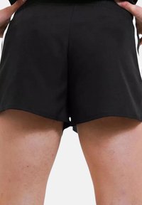 Pantaloni sportivi neri realizzati in tessuto leggero, con una vestibilità ampia, orlo curvato e un piccolo apertura sul retro per la traspirazione.