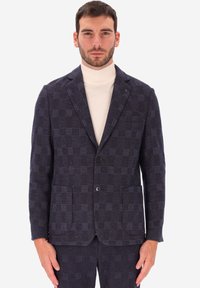 Blazer a quadri navy realizzato in tessuto testurizzato, con due tasche frontali, chiusura a un bottone, revers a punta e accenti grigi discreti.