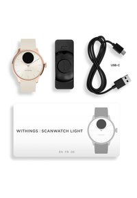 Withings ScanWatch Light: quadrante bianco rotondo, sottile cornice in oro rosa, cinturino in silicone, base di ricarica rotonda nera, cavo USB-C, scheda di istruzioni.