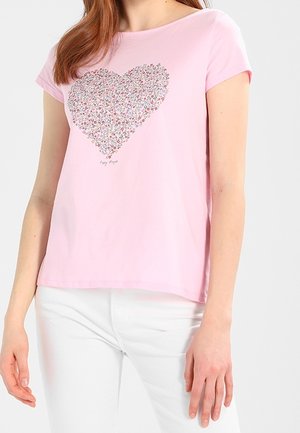 Różowa koszulka z krótkim rękawem z motywem serca, wykonana z wielokolorowych wzorów kwiatowych; miękka tkanina; luźny krój; okrągły dekolt.