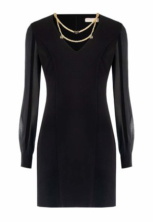 Mini abito nero a maniche lunghe con maniche trasparenti e dettaglio a catena dorata che drappeggia lungo lo scollo a V.