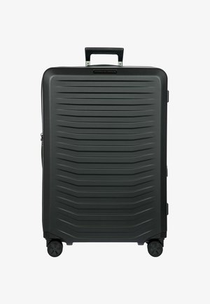 Valigia rigida nera con texture striata, maniglia telescopica e quattro ruote per la mobilità. Presenta una zip e tasche laterali.