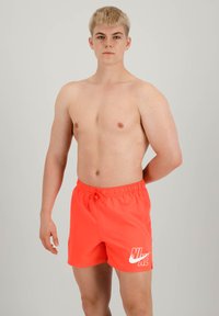 Neon narancssárga úszósort elasztikus derékpánttal és zsinórral, bal oldalon fehér Nike logóval. Sima tapintású.