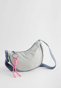 Borsa a spalla in nylon grigio chiaro con una forma curvata, dettagli blu e un portachiavi decorativo rosa. Caratterizzata da una tracolla regolabile.