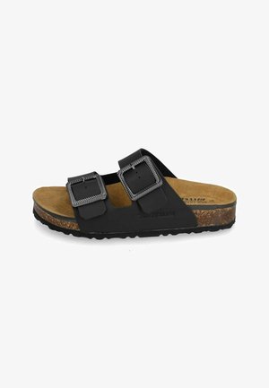 Sandalo nero slip-on con due fibbie in metallo regolabili, soletta in sughero e suola in gomma testurizzata, visto di lato su sfondo bianco.