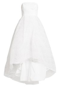 Robe blanche sans bretelles avec un ourlet asymétrique, dotée d'un tissu en dentelle superposée avec des motifs festonnés sur une couche lisse en dessous.