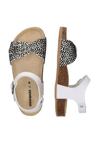 Zwart-witte sandals met stippen, voorzien van een verstelbare gespband, kurken voetbed en een witte verstelbare hielband. Plat zoolontwerp.