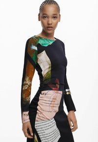 Robe à manches longues en tissu noir ornée d'imprimés abstraits colorés et de détails textuels, avec un design froncé mettant en valeur la taille.