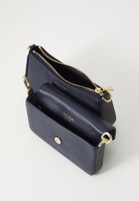 Sac à main en cuir navy avec une finition texturée, double compartiments, quincaillerie en doré et fermeture à pression.