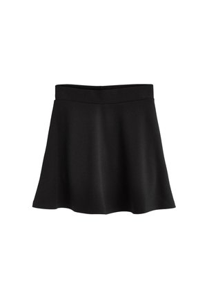 Crna suknja s razrijetim donjim dijelom i visokim strukom, izrađena od mekog materijala. Upari s crnim lakiranim cipelama i bijelim čarapama s volanima.