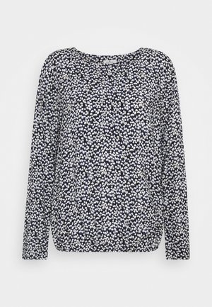 Blouse bleu marine à manches longues avec un petit motif floral abstrait blanc et violet clair et un col rond.