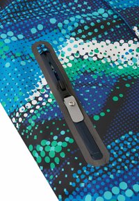 Bunt bedruckter Outdoor-Jackenstoff mit blauen, grünen und weißen Punkten. Verfügt über einen grauen Reißverschluss und eine strukturierte Oberfläche.