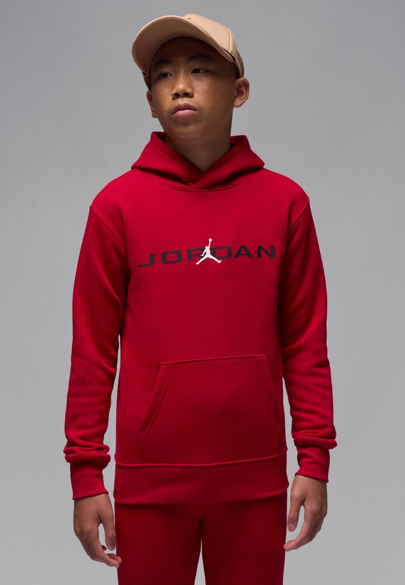 Red hooded sweatshirt with a front pocket. Features a black "JORDAN" logo and Jumpman graphic in white. Smooth fabric, snug fit.