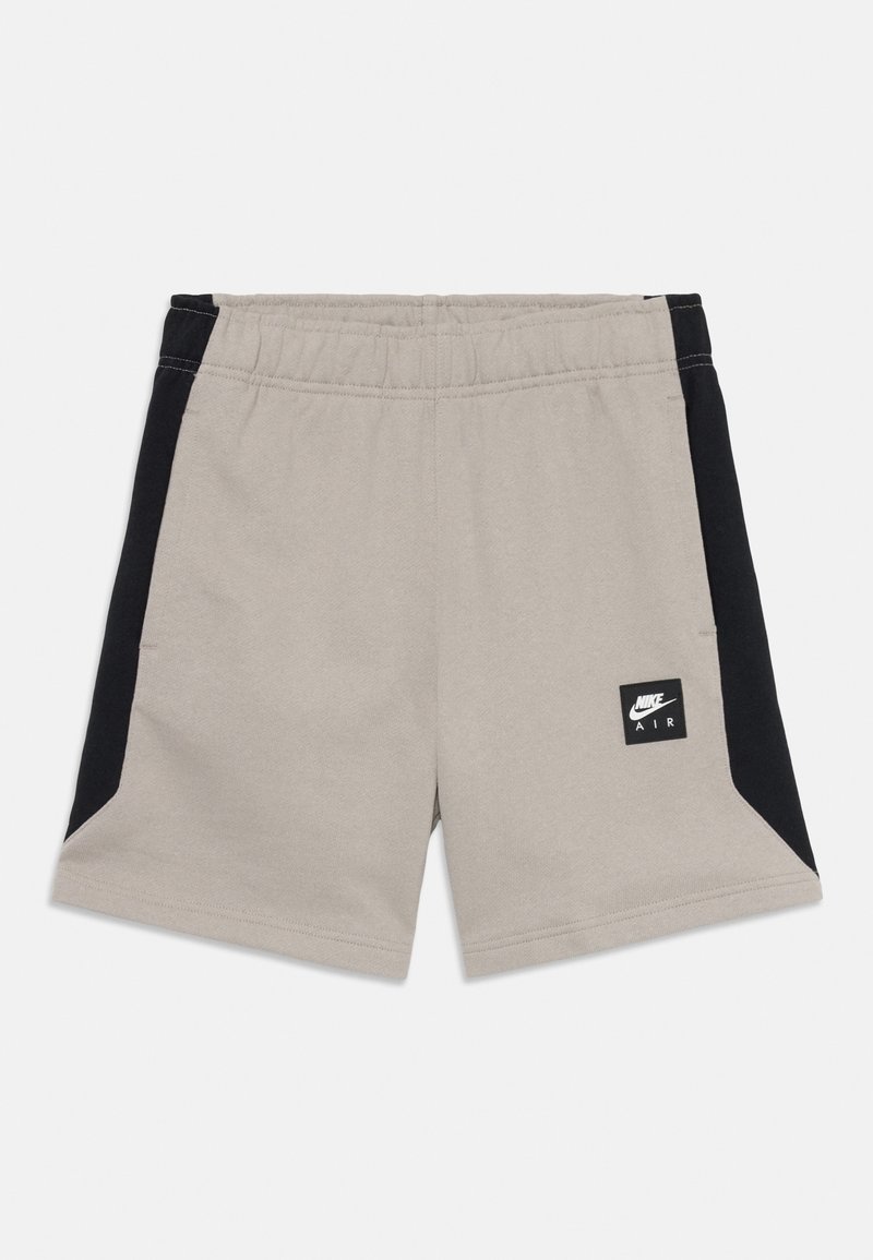 Shorts Nike Air beige et noirs avec une taille élastique et un patch logo sur la partie avant de la jambe droite.
