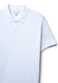 Biała koszulka polo wykonana z bawełny, z kołnierzykiem, z trzema guzikami z przodu oraz krótkimi rękawami z teksturowanym wzorem. Widoczna etykieta marki.