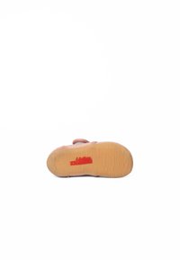 Różowy materiałowy but z teksturowaną podeszwą, z czerwonym logo i zapięciem na rzep. Podeszwa ma kolor gumy i liniowe wzory.