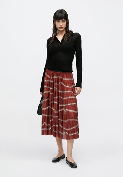 Must pikkade varrukatega pluus nööpidega kraega, koos kortsplekilise roostepunase midi seelikuga, millel on valged ja beežid triibud ning geomeetrilised mustrid.