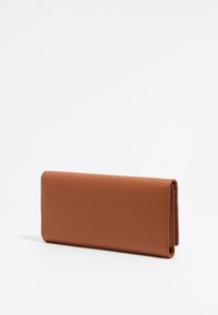 Billetera de cuero marrón con una textura suave, forma rectangular y un diseño delgado. Presenta un cierre plegado y un perfil minimalista.