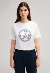 Witte katoenen T-shirt met een ronde zwarte graphic waarin het herhaalde woord "JOOP!" staat en een ankerontwerp, gecombineerd met een marineblauwe broek.