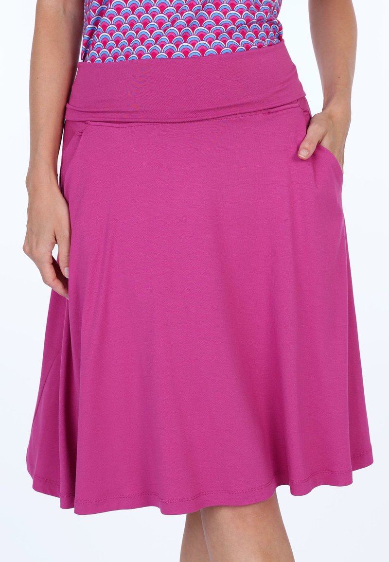 Magenta Rock mit einem dehnbaren Bund. Es verfügt über ein fließendes Design, ist knielang und hat Seitentaschen, hergestellt aus weichem, leichtem Stoff.
