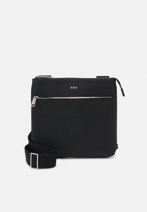 Borsa a tracolla nera realizzata in materiale testurizzato, con tasca frontale con zip e tracolla regolabile con fibbia in metallo e dettaglio del logo.