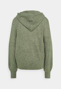 Zielona, prążkowana bluza z kapturem o miękkiej fakturze, wyposażona w tylne szwy i luźny krój. Projekt uzupełniają kaptur oraz długie rękawy.