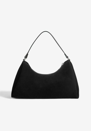 Juodas suede rankinukas su kreiva siluetu, plokščiu dugnu ir vienu juodu peties diržu, kuriame yra zip užtrauktukas viršuje.